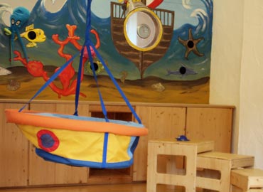 Kinderschaukel vor bunt bemalter Wand